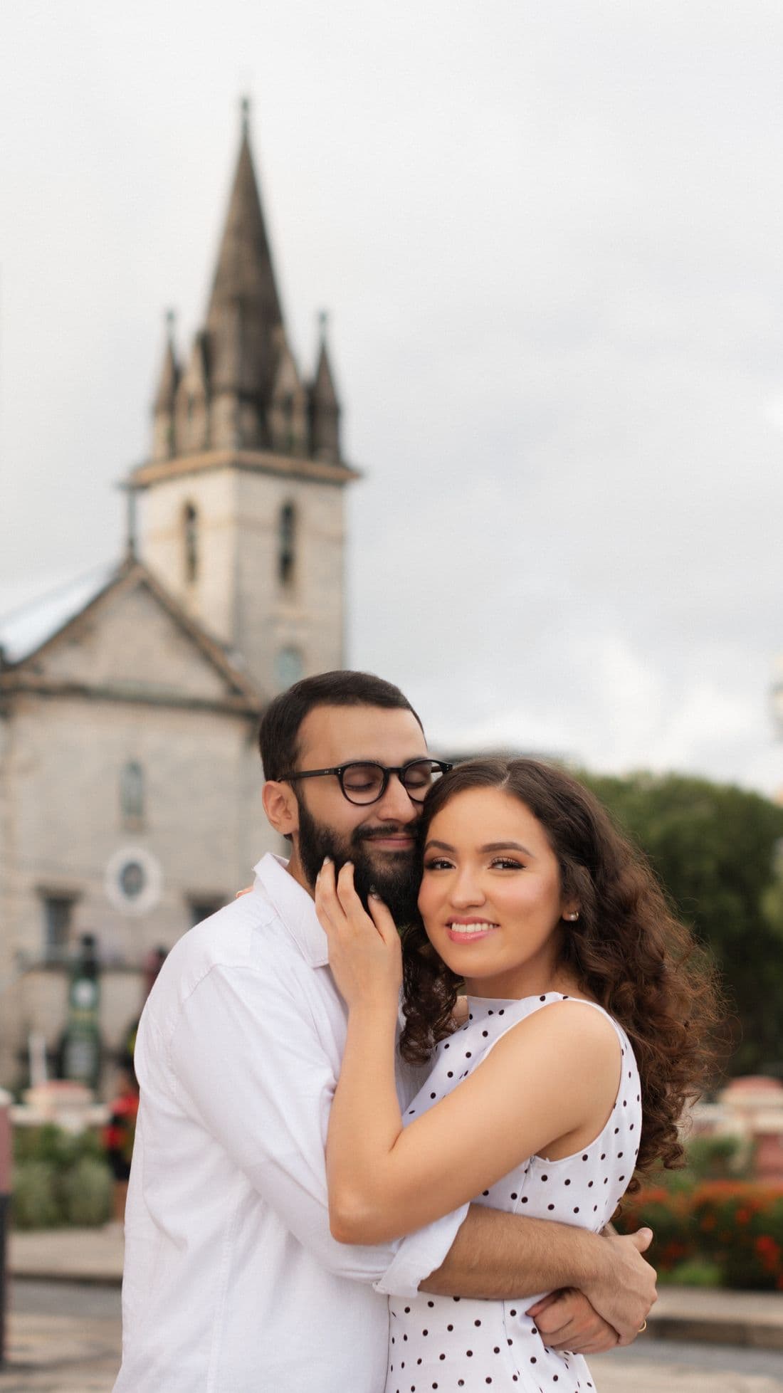 Gabriel e Geovanna abraçados em frente a uma igreja
